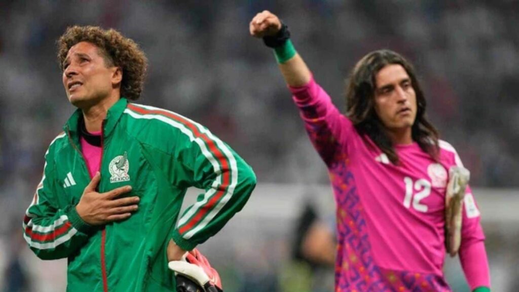 seleccion-mexicana-quedo-eliminada-del-mundial - NL Directo Two soccer players celebrate on the field, one in a green Mexico jacket and the other in a pink goalkeeper kit, raising a fist.