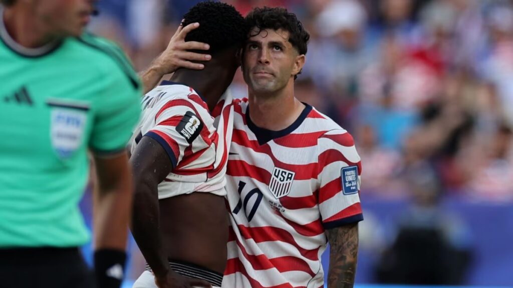 trump-Folarin-FIFA-2026-Balogun - NL Directo Two USA soccer players hug on the field, one facing the camera in a red‑and‑white striped jersey with number 10 while the other rests his arm around his shoulder.